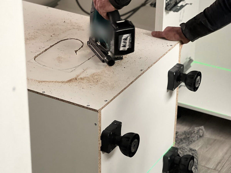 Küchenmontage: Unterschrank mit Stellfüßen und Laserlinie ausrichten, Ausschnitt in der Platte (Symbolbild)